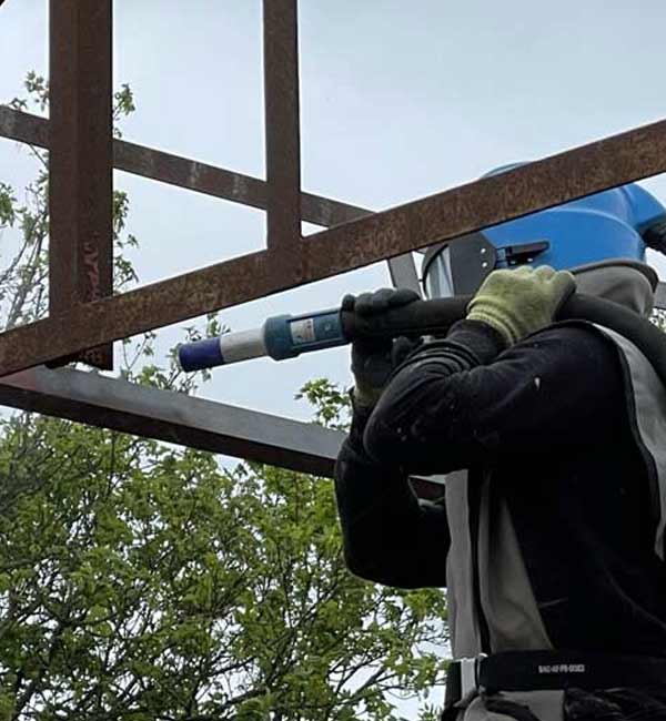 Rust removal from metal frame at construction project near Reading, Berkshire